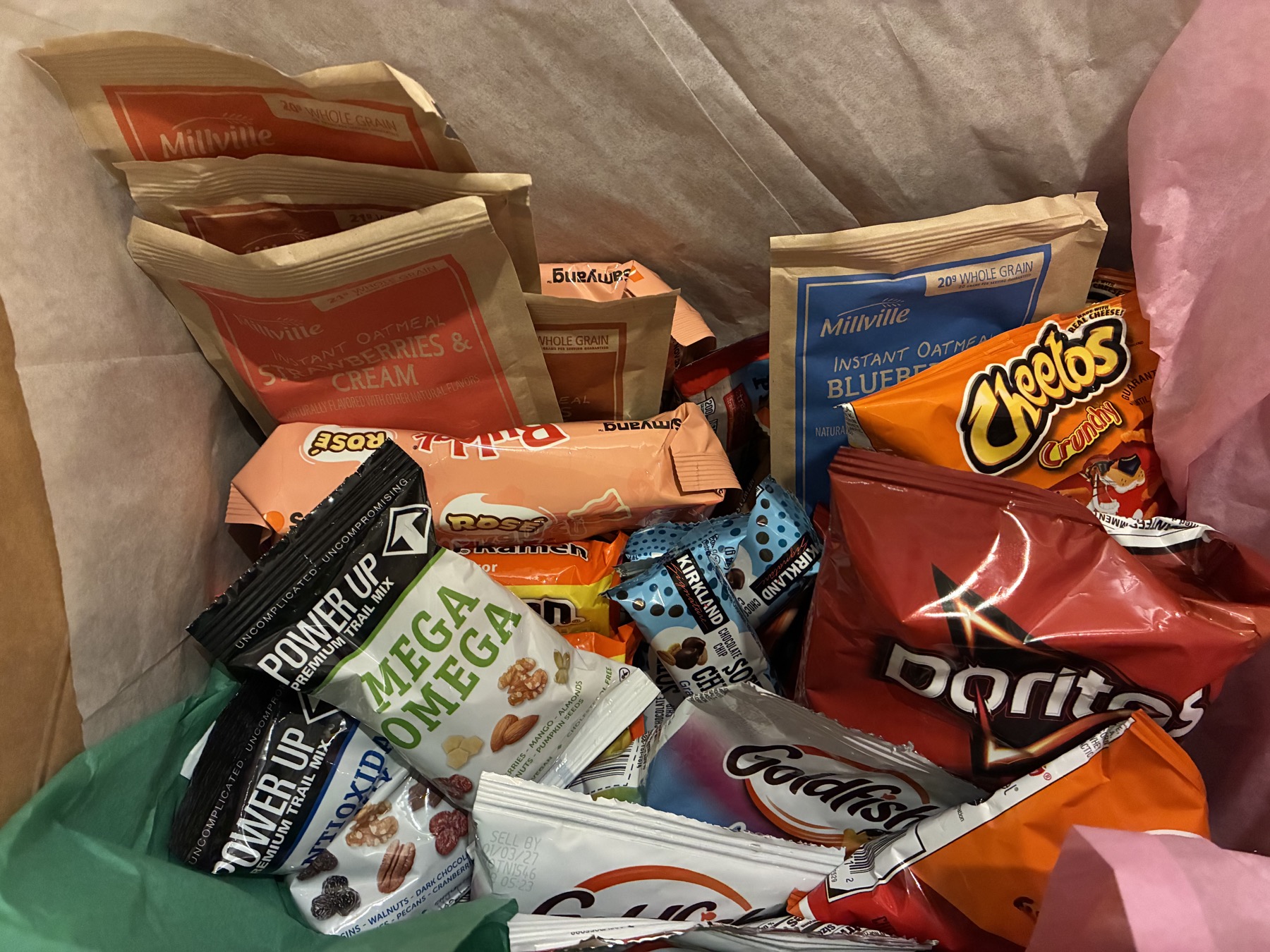 Care package filled with snacks and colorful tissue paper